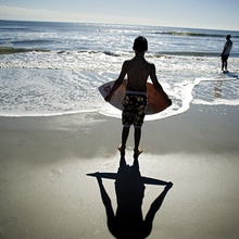 Boy on beach with surf board